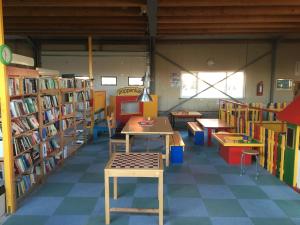 una biblioteca con mesas y estanterías de libros en Het Landhuis, en Oostkapelle