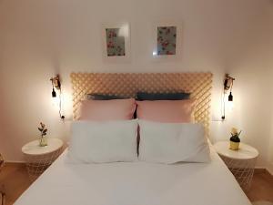 a bedroom with a white bed with two tables at Paraíso en la Loma de Santa Pola in Gran Alacant