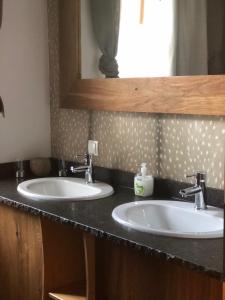 a bathroom with two sinks and a mirror at Romantik Chalet in Breitenbrunn
