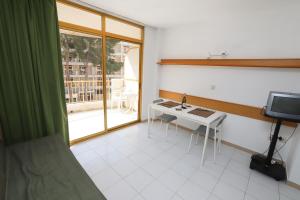 サロウにあるCOSTA DAURADA APARTAMENTS -102 Internacionalのテーブルと窓が備わる小さな客室です。