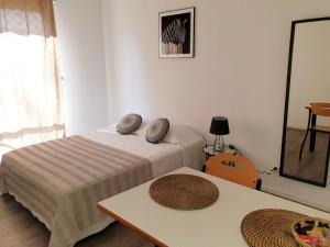 a bedroom with two beds and a table and a mirror at Neoresid - Résidence Clos Morlot in Dijon