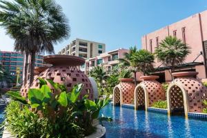 a row of large vases sitting next to a swimming pool at Marrakesh Huahin 1 bedroom with pool access 307 in Hua Hin