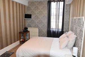 1 dormitorio con cama blanca y ventana en Les chambres du Foulot, en Beaune