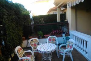 a patio with a table and chairs on a porch at Adosado con Patio Punta Umbria in Punta Umbría