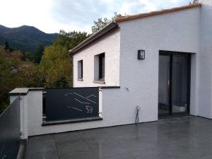 Un edificio blanco con un cartel al costado. en Casa Vilallonga, en Villelongue-dels-Monts