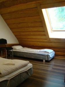 two beds in a room with a wooden ceiling at Isakaru Puhkemaja in Otepää