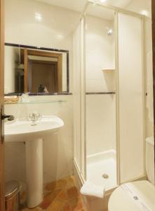 y baño blanco con lavabo y ducha. en Hospederia Sagasta en Torrecilla en Cameros