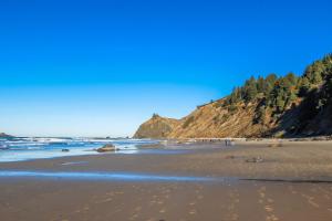 a beach with people walking on the sand at The Lucky Starfish in Lincoln City
