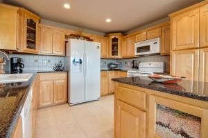 cocina con armarios de madera y nevera blanca en High View Retreat, en Lago Vista