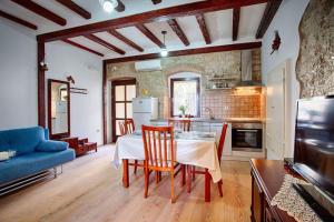 Ul. Ivana Farolfija 12 Apartman Domina في فيس: مطبخ وغرفة معيشة مع طاولة وأريكة زرقاء