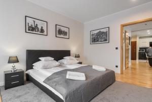 a bedroom with a large bed with two towels on it at Prestige Apartamenty Bystra Woda Centrum in Zakopane