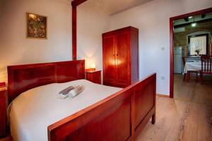 1 dormitorio con 1 cama grande con marco de madera en Ul. Ivana Farolfija 12 Apartman Domina en Vis