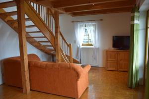 een woonkamer met een bank en een trap bij Ferienwohnungen Wagner in Gamlitz