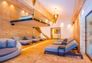 a waiting room with blue chairs and a staircase at Hotel Gaspingerhof in Gerlos