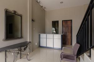 sala de estar con espejo y silla en RedDoorz near Puri Indah Mall, en Yakarta