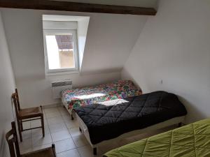 Cette petite chambre comprend 2 lits et une fenêtre. dans l'établissement Le gîte de Magaly, à Wissant