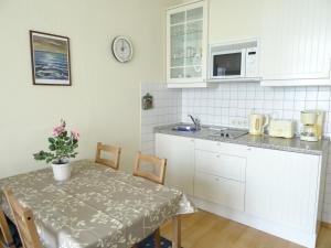 eine Küche mit einem Tisch und einer Arbeitsplatte in der Unterkunft Fürstenhof Fewo Grönland in Sassnitz