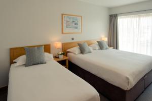 2 Betten in einem Hotelzimmer mit Fenster in der Unterkunft Waterford Viking Hotel in Waterford