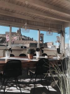 una mesa y sillas en una habitación con vistas en Attico Da Rosa con vista spettacolare a 360 gradi, en Caltagirone