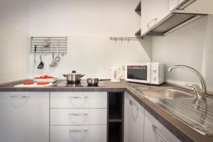 uma cozinha com um lavatório e um micro-ondas em Casa Girasole em Bardolino