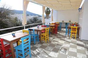 a restaurant with colorful tables and chairs on a balcony at Halikarnas Pansiyon in Bodrum City