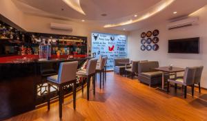 a bar in a restaurant with tables and chairs at Red Fox Hotel, Alwar in Alwar