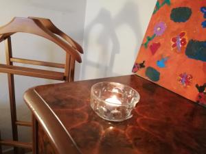 eine Kerze in einer Schüssel auf einem Tisch mit einem Stuhl in der Unterkunft Via Giovanni Travaglia, FREE SPACE in Palermo