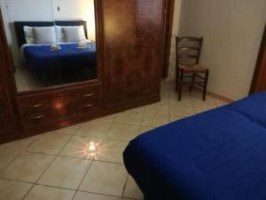 ein Schlafzimmer mit einem Spiegel, einem Bett und einem Stuhl in der Unterkunft Via Giovanni Travaglia, FREE SPACE in Palermo