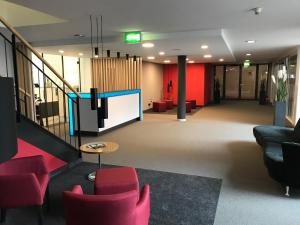 a lobby with red chairs and a flat screen tv at Hotel & Apart4you in Dorfen