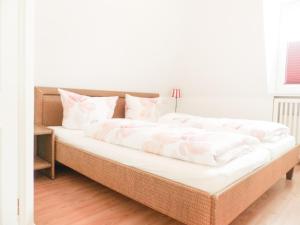een groot bed met witte lakens en kussens erop bij Suite Boysen No.15 in Westerland