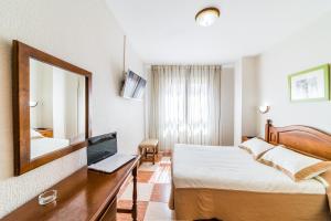 
a bedroom with a bed, desk and a laptop at Hotel Sevilla in Almería
