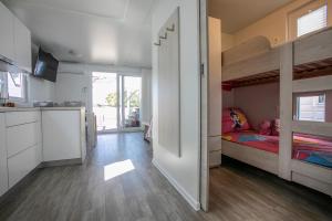 a bedroom with a bunk bed and a kitchen at Floating Sea House Principessa in Portorož