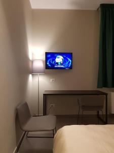 ein Schlafzimmer mit einem Bett und einem TV an der Wand in der Unterkunft AREA 19 in Catanzaro
