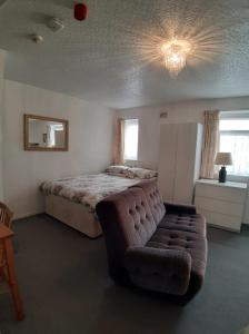a bedroom with a bed and a couch at Rosemede Holiday Flats in Blackpool