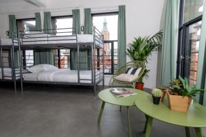 una stanza con letti a castello, tavolo e sedie di Pink Flamingo Boutique Hostel a L'Aia