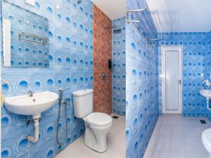 La salle de bains bleue est pourvue de toilettes et d'un lavabo. dans l'établissement Gold City Hotel, à Malacca