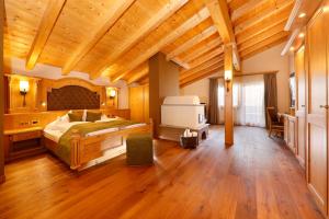 a bedroom with a large bed and a wooden ceiling at Hotel Plunhof in Ridanna +120 photos