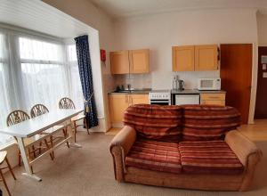 a living room with a couch and a table and a kitchen at Rosemede Holiday Flats in Blackpool +34 photos
