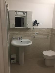 łazienka z umywalką, toaletą i lustrem w obiekcie Casa Vacanza La Pergola w mieście Terrasini