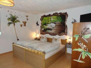 - une chambre avec un lit orné d'une peinture murale dans l'établissement Pension Sonnenhügel, à Markersdorf