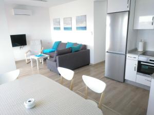 uma cozinha e uma sala de estar com um sofá e uma mesa em Apartamentos Poniente em Vilanova de Arousa