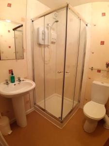 a bathroom with a shower and a toilet and a sink at Rosemede Holiday Flats in Blackpool