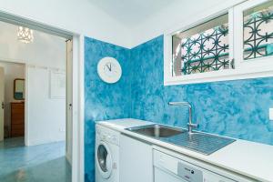 uma cozinha com um lavatório e uma máquina de lavar roupa em Liiiving in Algarve - Alvor Blue Villa em Alvor