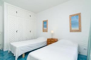 two beds in a bedroom with white walls and blue floors at Liiiving in Algarve - Alvor Blue Villa in Alvor