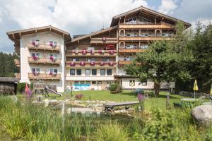 a hotel with a pond in front of it at Hotel Steiger in Neukirchen am Großvenediger