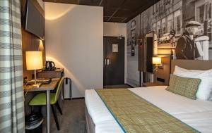 a hotel room with two beds and a refrigerator at Hotel Cornelisz in Amsterdam
