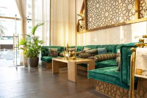 a living room filled with furniture and a large window at Samaya Hotel Deira in Dubai