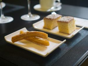 two plates of food on a table with desserts at Carris Cardenal Quevedo in Ourense