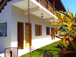 a house with a swing in front of it at Balangan Flats in Ubatuba