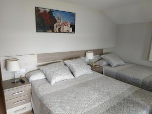 una camera da letto con due letti e un quadro sul muro di Hotel Playa a Cangas de Morrazo